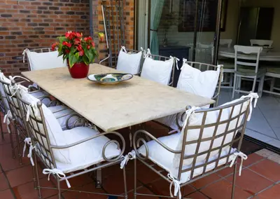 a table with chairs and a vase of flowers on it at Kaniek - Guest Suite in Somerset West