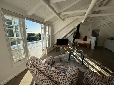 a living room with two couches and a television at The Bothey House in Somerset West