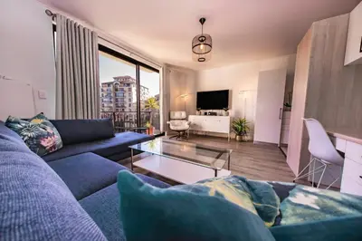 a living room with a blue couch and a tv at La Savina On Lake 219 The Island Club in Cape Town