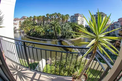 a balcony with a view of a river and palm trees at La Savina On Lake 219 The Island Club in Cape Town