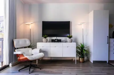 a living room with a tv and a white cabinet at La Savina On Lake 219 The Island Club in Cape Town