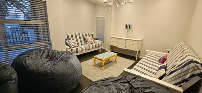 a living room with two chairs and a table at C-Onrus in Hermanus