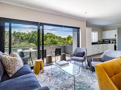 a living room with a couch and chairs and a table at FamoHof Apartments in Stellenbosch
