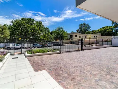 a black wrought iron fence with a garden at FamoHof Apartments in Stellenbosch