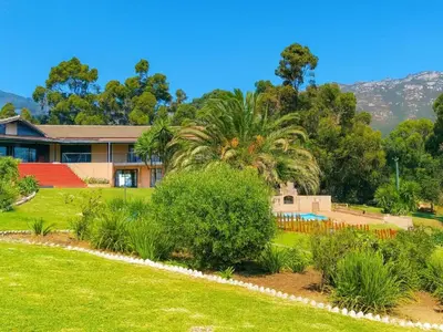 a house with a garden in front of it at Into the Sunset Manor in Gordonʼs Bay