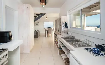 a kitchen with a sink and a view of the ocean at Vermont Vista - With Pool in Hermanus