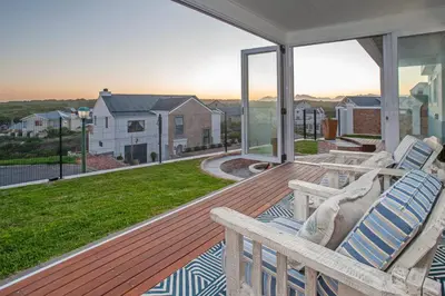 a porch with two chairs and a view of a house at Vermont Vista - With Pool in Hermanus