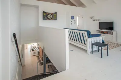 a room with a staircase with a chair and a television at Vermont Vista - With Pool in Hermanus