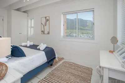 a white bedroom with a bed and a window at Vermont Vista - With Pool in Hermanus