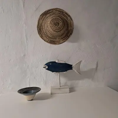 a bowl and a fish sculpture on a table at Vermont Garden Cottage in Hermanus