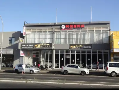 a large building with cars parked in front of it at Ngena Sleep and Go Goodwood in Goodwood