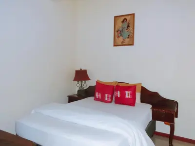 a bedroom with a white bed with red pillows at Ngena Sleep and Go Goodwood in Goodwood