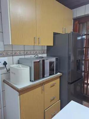 a kitchen with a microwave and a refrigerator at Azzure Apartments 4 sleeper Crawford in Cape Town
