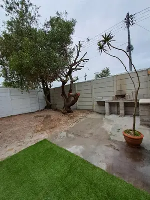 a yard with a bench and a tree and a fence at Azzure Apartments 6 sleeper Crawford in Cape Town