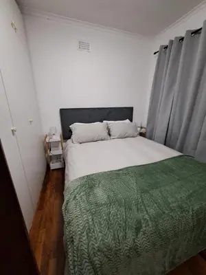 a bedroom with a large bed with a green blanket at Azzure Apartments 6 sleeper Crawford in Cape Town