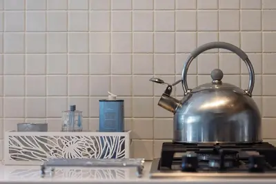 a tea kettle sitting on top of a stove at Arch Window garden apartment in Stellenbosch