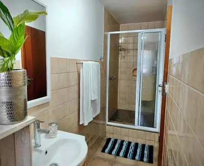 a bathroom with a shower and a sink and a shower at Sand Sittie in Sandbaai