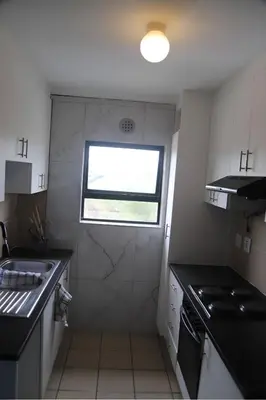 a small kitchen with a sink and a window at Browns villa in Cape Town
