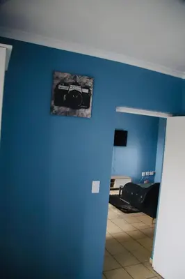 a blue room with a picture of a camera on the wall at Browns villa in Cape Town