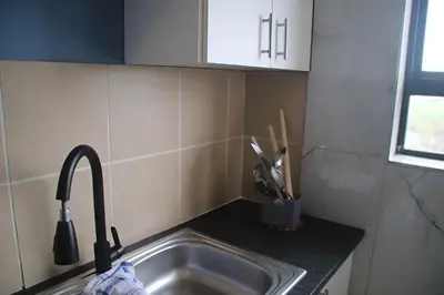 a kitchen sink with a kitchen utensils in a container at Browns villa in Cape Town