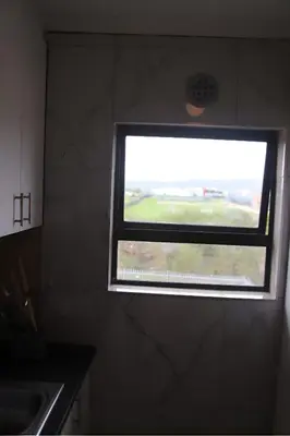 a window in the corner of a kitchen with a counter at Browns villa in Cape Town