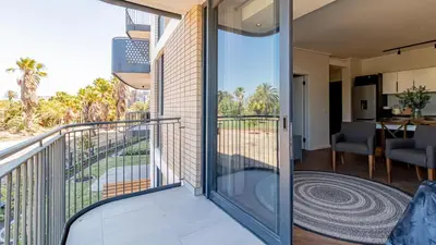 a balcony with a glass door leading to a living room at Table Mountain View Apartment in Cape Town