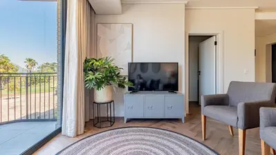 a living room with a tv and a chair at Table Mountain View Apartment in Cape Town