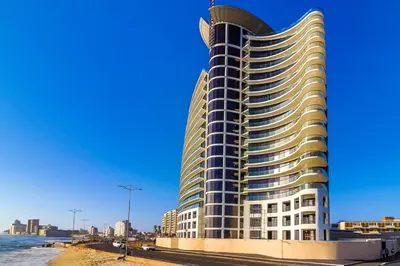 a tall building on the beach with the ocean at 402 Ocean View in Strand