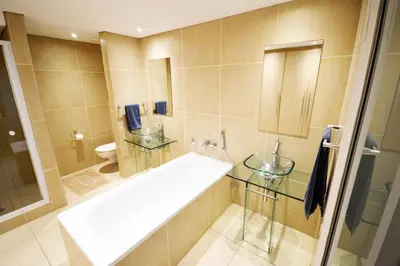 a bathroom with a tub and a sink and a toilet at 402 Ocean View in Strand