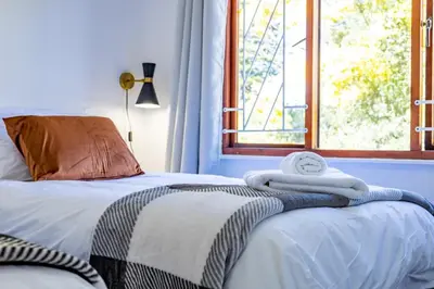 a bedroom with two beds and a window at Bed On Boucher in Durbanville