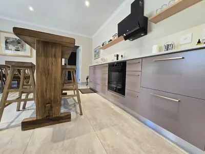 a kitchen with a wooden table in the middle at Susans Cottage Peace and Quiet in Villiersdorp