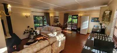 a living room with a couch and a table at Sunkiss Cottage on Mount Joy Farm in Stellenbosch