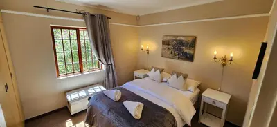 a bedroom with a large bed and a window at Sunkiss Cottage on Mount Joy Farm in Stellenbosch