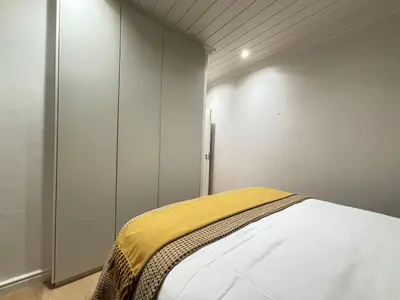 a bedroom with a bed with a yellow blanket on it at Modern living in central town in Stellenbosch