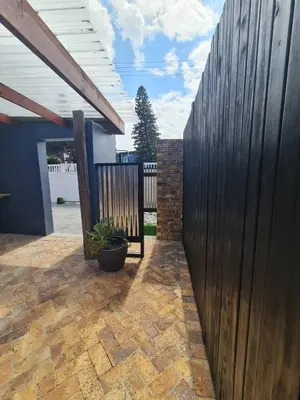 a wooden fence in a backyard with a potted plant at LieBling Place in Cape Town