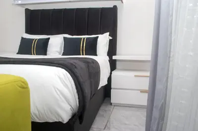 a bedroom with a large bed with a black headboard at Optimum Stay Self Catering Accommodation - Junior Suite in Parow