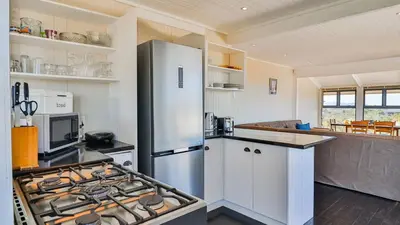 a kitchen with a stainless steel refrigerator and a stove at BluCabana 500m from Main Beach in Bettyʼs Bay
