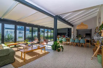 a living room with a couch and tables and chairs at Pikkewyn Paradise in Hermanus