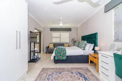 a bedroom with a bed and a couch at Pikkewyn Paradise in Hermanus