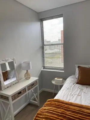 a bedroom with a bed and a table with a mirror at Boerbok & Bloom in Paarl