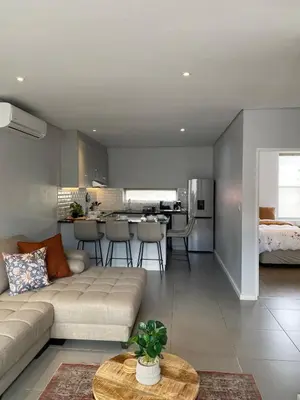 a living room and kitchen with a couch and a table at Boerbok & Bloom in Paarl