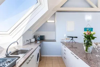 a kitchen with a sink and a skylight at Dolphin Beach H305 in Cape Town
