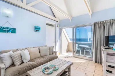 a living room with a couch and a table at Dolphin Beach H305 in Cape Town