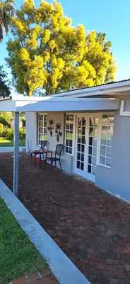 a house with a red bench on a brick patio at Firehouse guest suite no 3 in Wellington