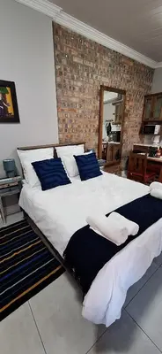 a large bed with blue pillows in a bedroom at Firehouse guest suite no 3 in Wellington