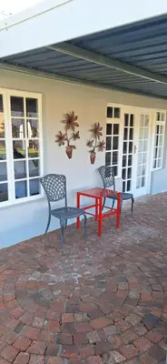 two chairs and a red table on a patio at Firehouse guest suite no 3 in Wellington