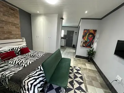 a bedroom with a zebra print bed in a room at Blade Flatlet in Silver Sands