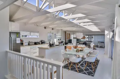 a kitchen and dining room with a table and chairs at Nordic Family Beach House in Bettyʼs Bay