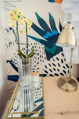 a glass vase on a table next to a lamp at Roubaix House - A Heritage Retreat in the Heart of Franschhoek in Franschhoek