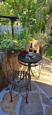a table with a bottle of wine and two glasses at Petite Vine in Stellenbosch
